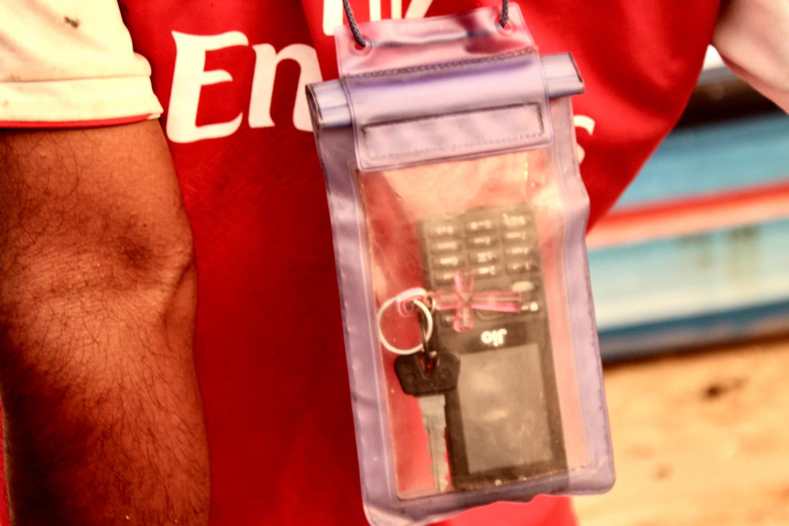 A fisherman keeps his mobile phone in a waterproof plastic pouch. Fishers routinely carry basic handsets that can help them communicate upto ten miles from the shore. Image: Max Martin