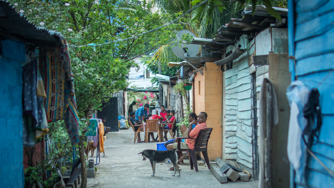 People sit outside their brightly coloured homes in Colombo.